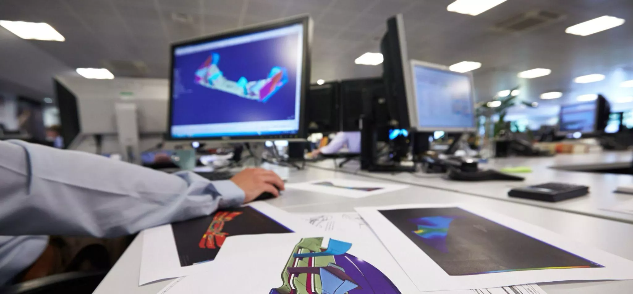 F1 engineer looking at a 3D render of a front wing on a computer