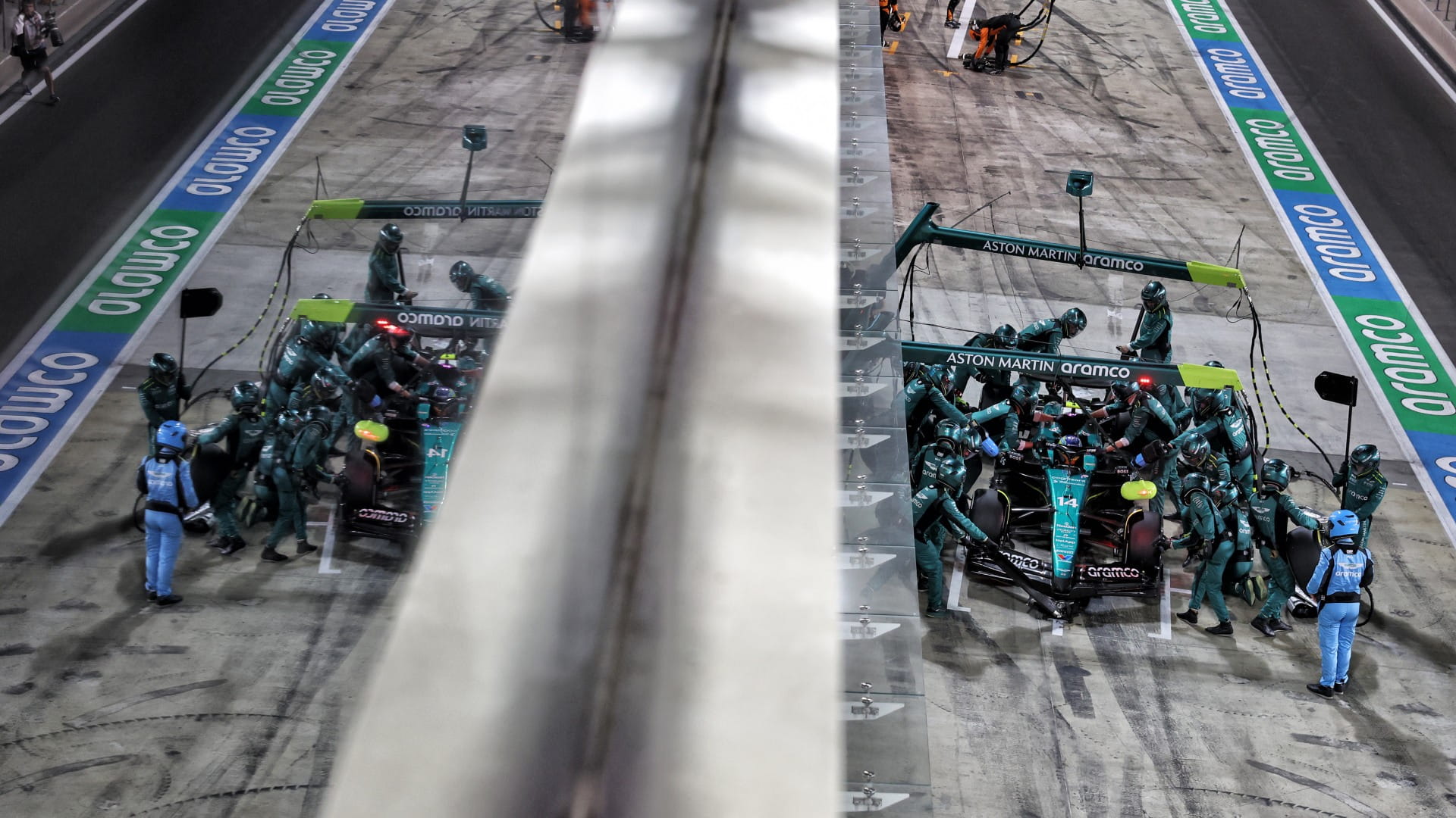 The Aston Martin F1 car in the pitlane with a reflection from a window showing the car in another angle
