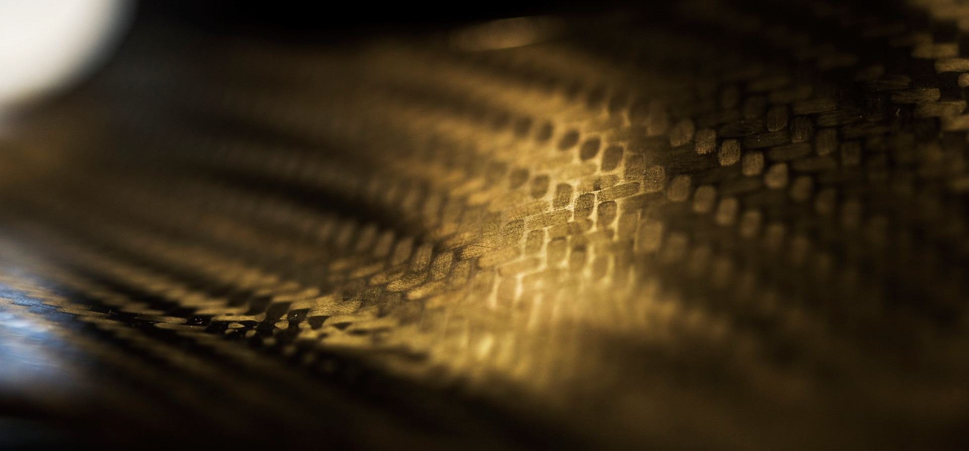 Closeup of carbon fibre weave on an F1 car showing a black glossy finish
