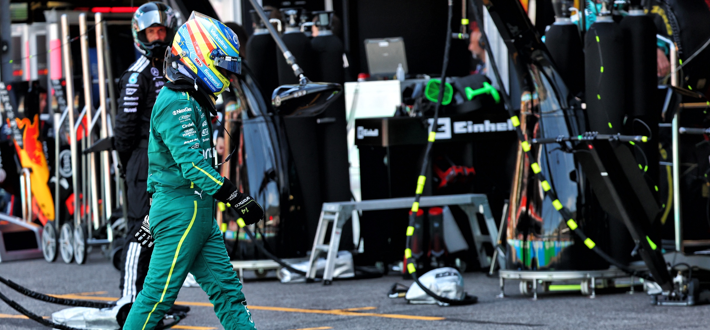 Fernando Alonso walks into the Aston Martin garage after his Mercedes power unit gave way in Monaco