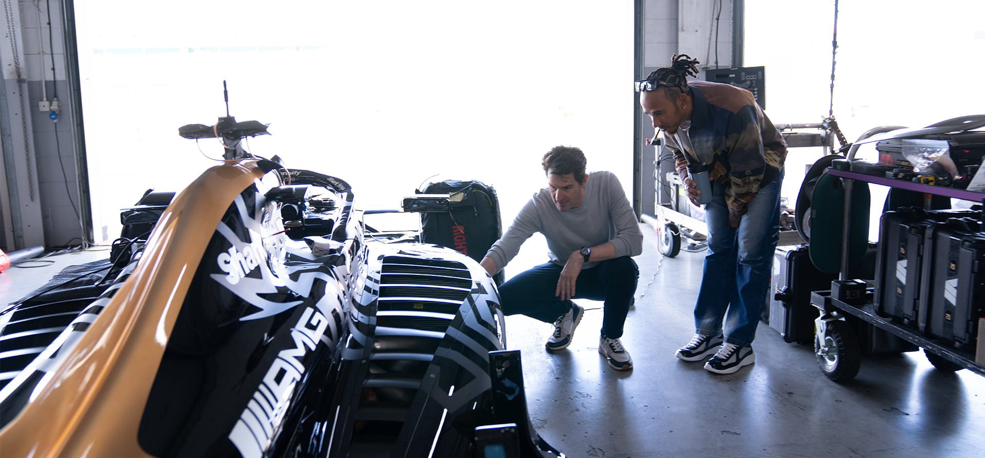 F1 The Movie APX GP car, Lewis Hamilton and Joseph Kosinski examining