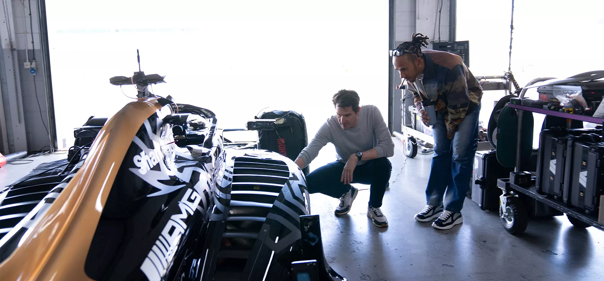 F1 The Movie APX GP car, Lewis Hamilton and Joseph Kosinski examining