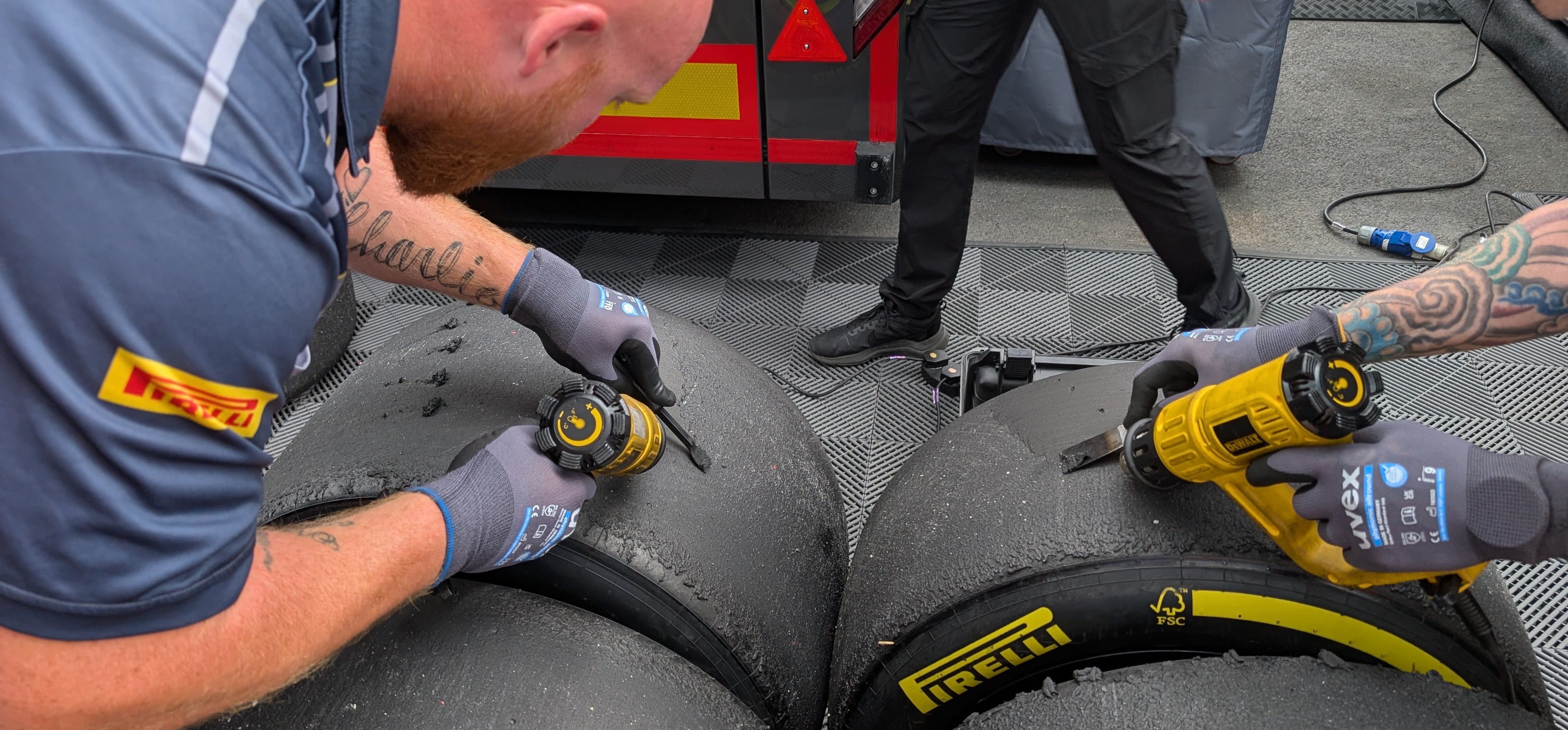 Pirelli F1 tyres with engineers measuring tread wear