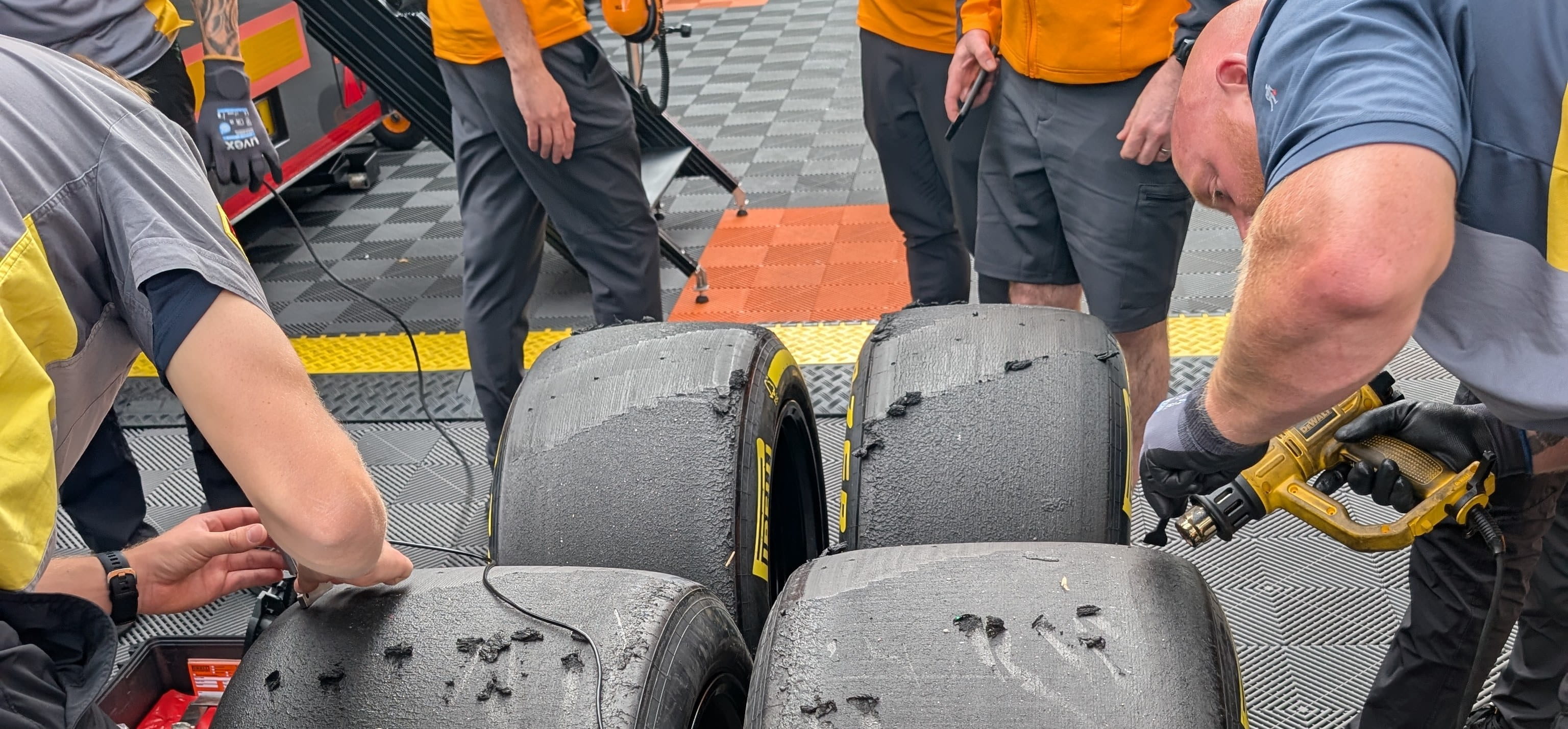 Pirelli F1 tyres with engineers measuring tread wear
