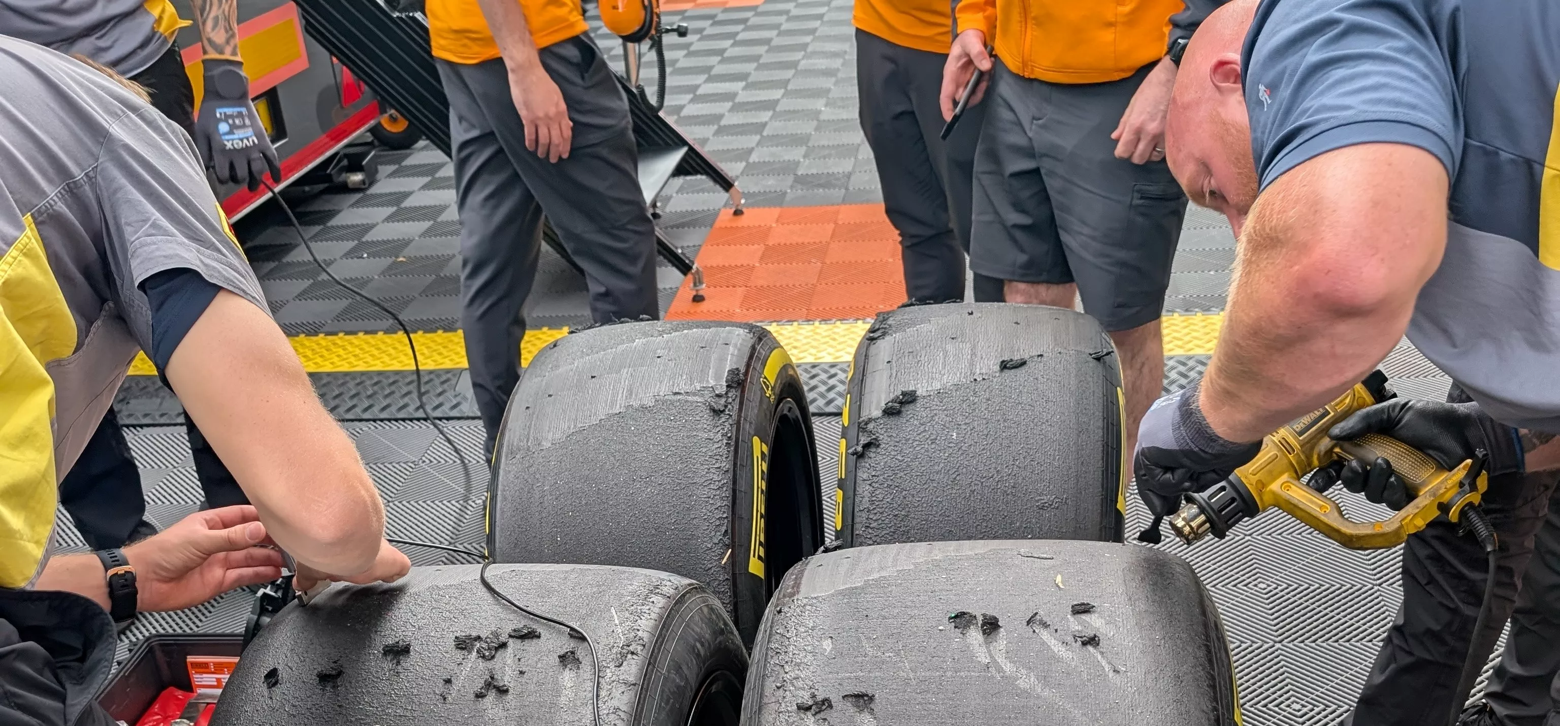 Pirelli F1 tyres with engineers measuring tread wear