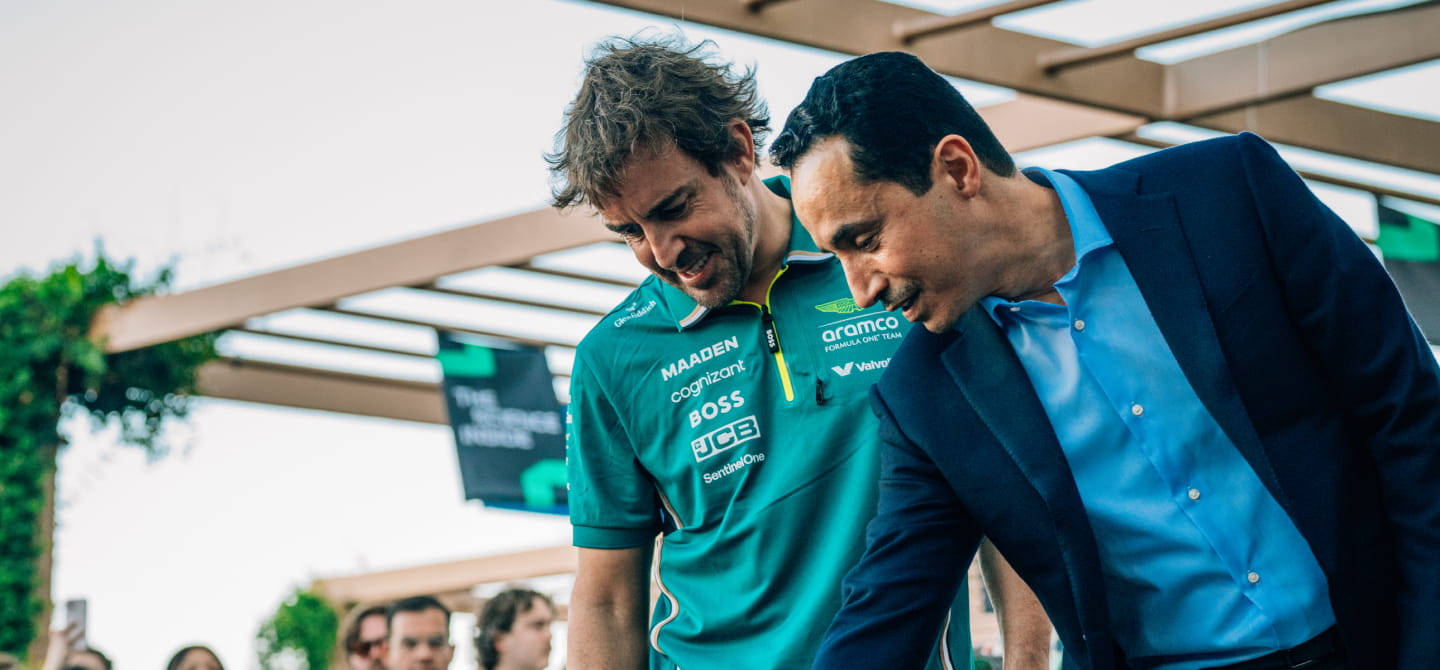 Alonso and Aramco executive looking at F1 car