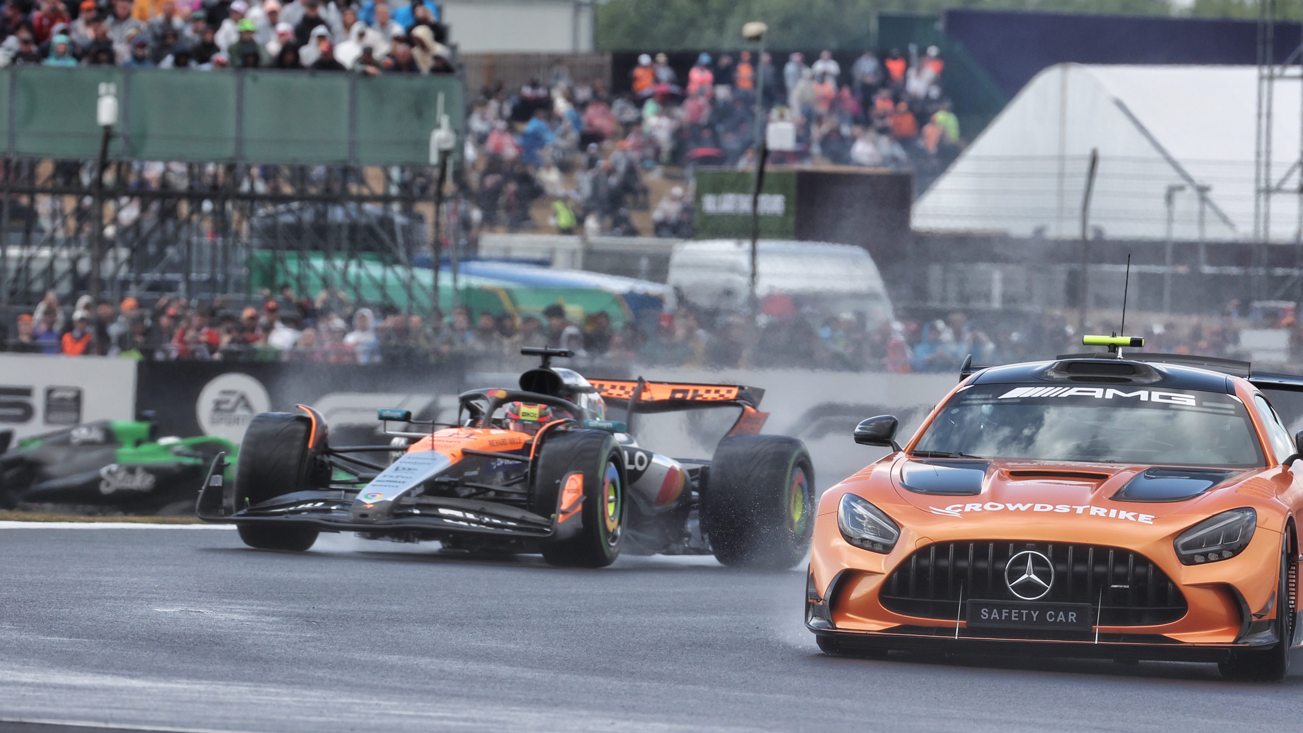 McLaren F1 car in rain behind safety car
