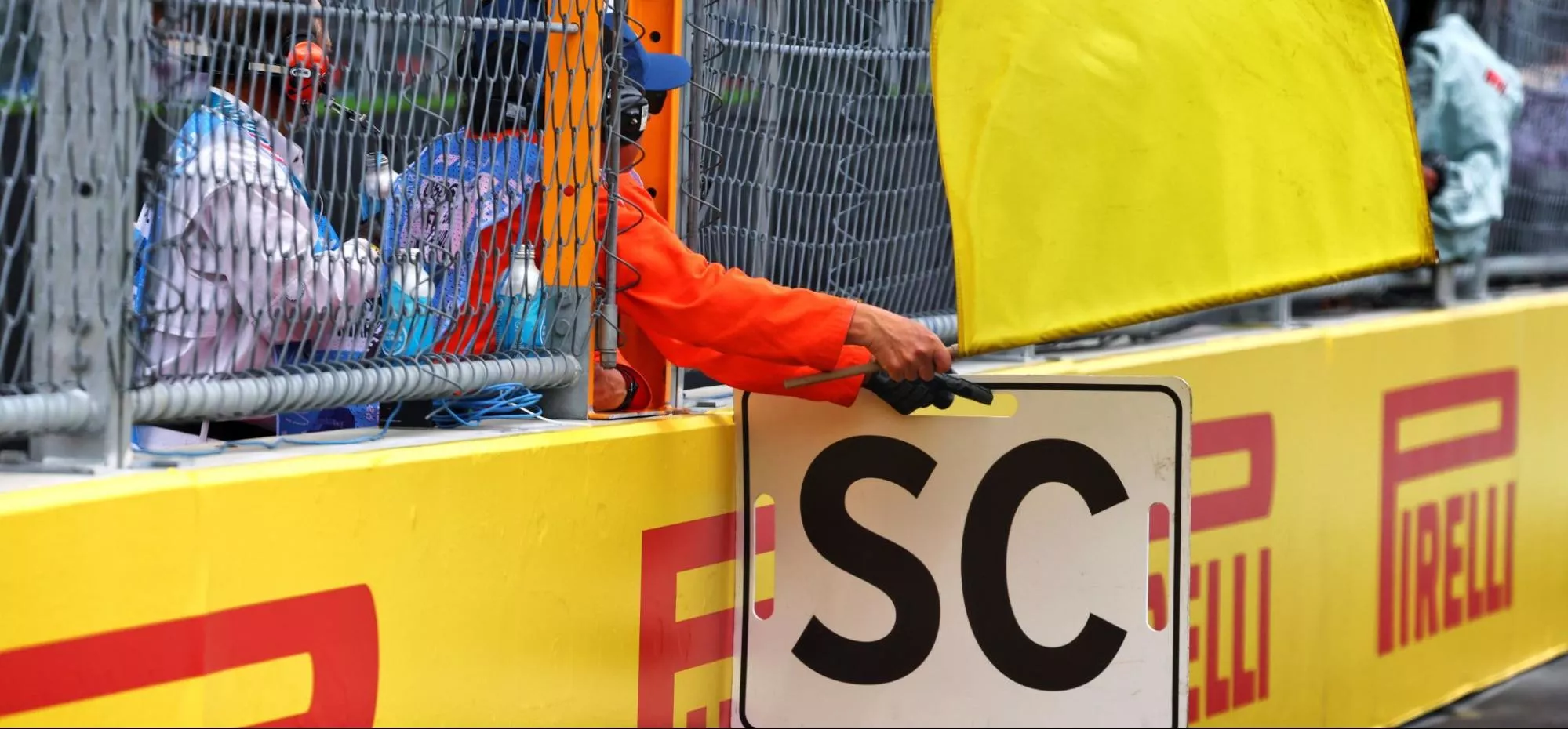 A volunteer holds up an ‘SC’ board denoting the presence of a safety car